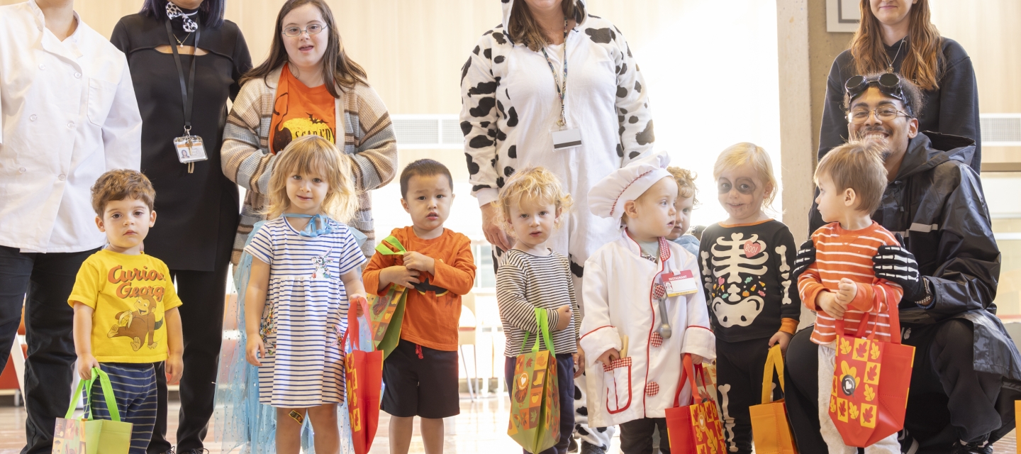 Group of children and adults trick or treating in the library.